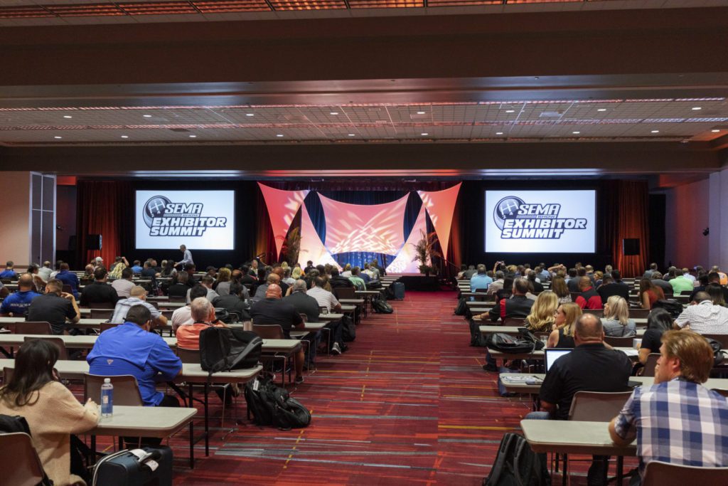 People sitting at conference tables at a trade show.